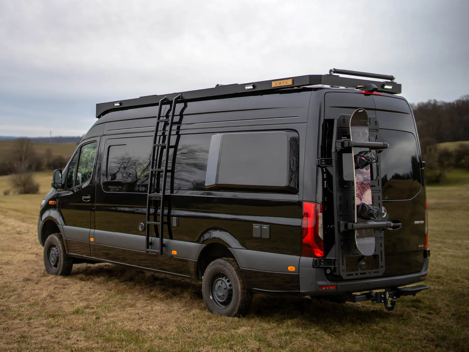 Schwarzer Allrad-Sprinter Emil mit Dachträger als autarker Camper-Ausbau
