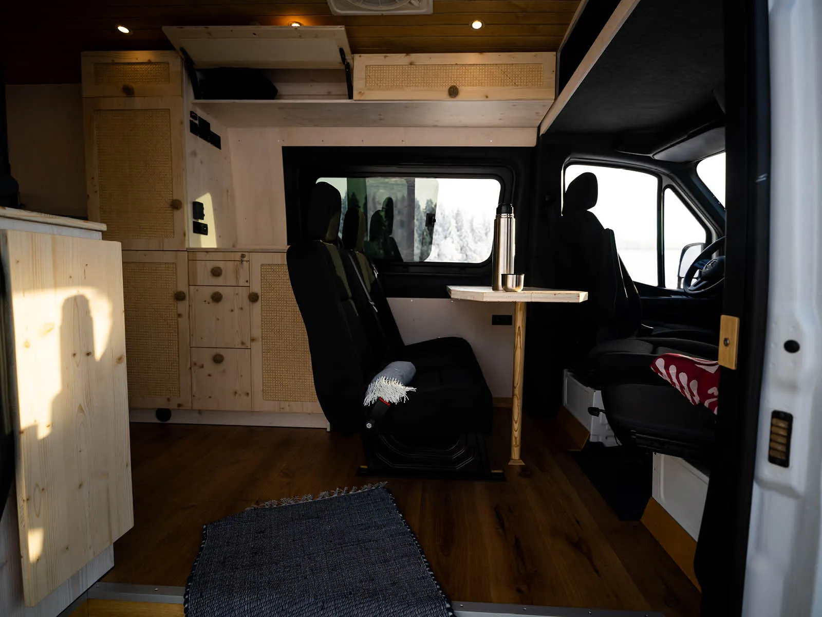 Innenraum von Gido mit Tisch, Stauraum und Fahrerhaus im Mercedes Sprinter