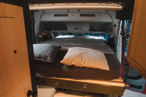 Ausgefahrenes Hub-Slide-Bett im MAN-Trailer Campervan
