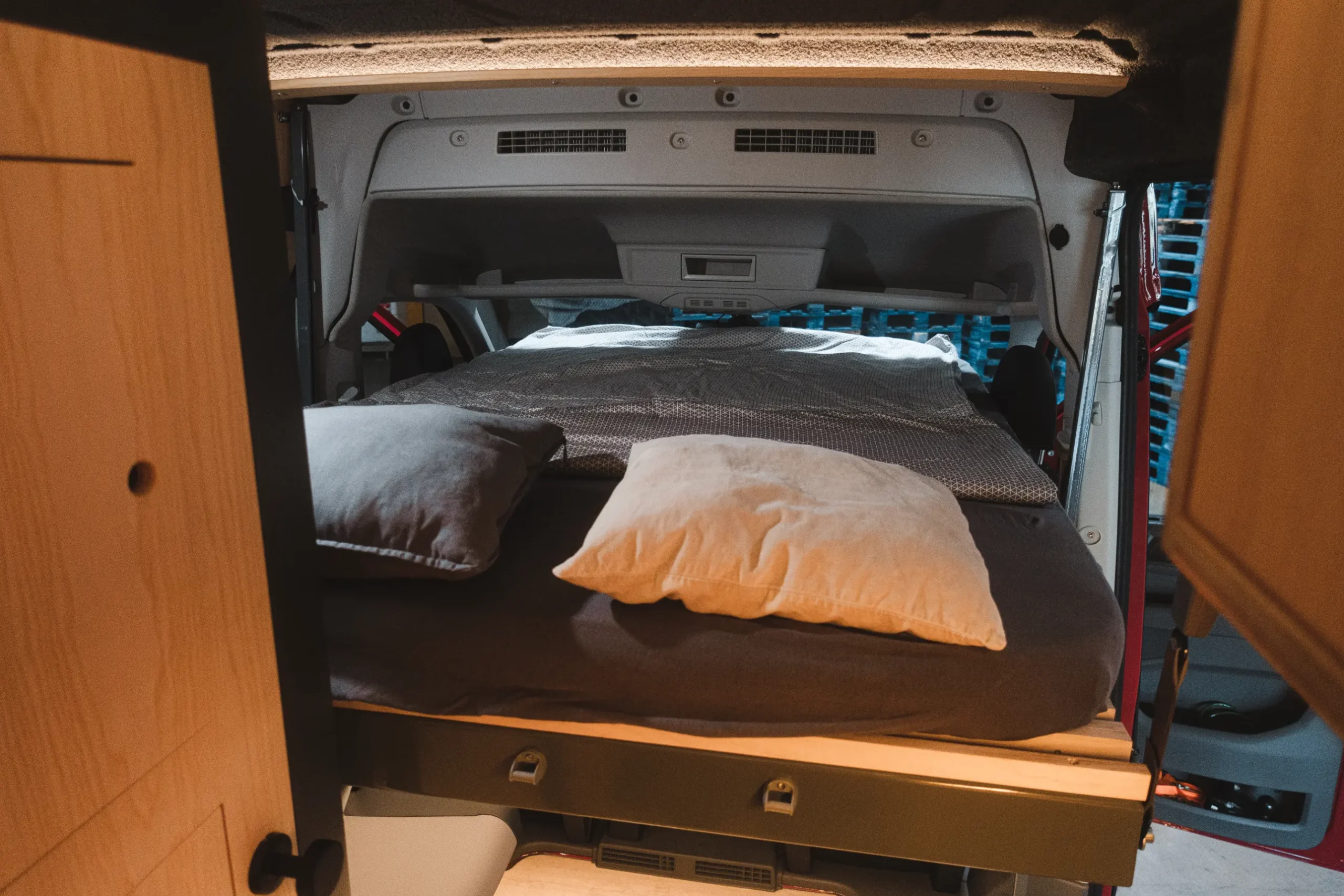 Ausgefahrenes Hub-Slide-Bett im MAN-Trailer Campervan
