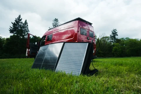 Mobile Solartaschen vor dem roten MAN-Trailer Campervan