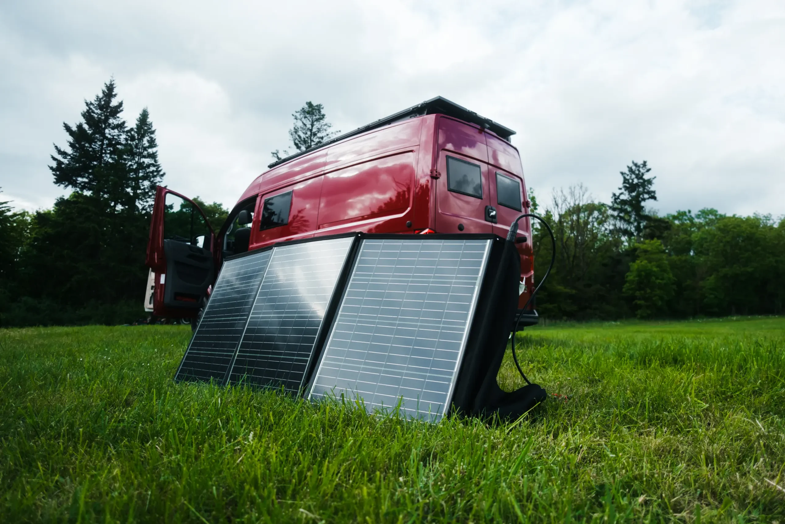 Mobile Solartaschen vor dem roten MAN-Trailer Campervan