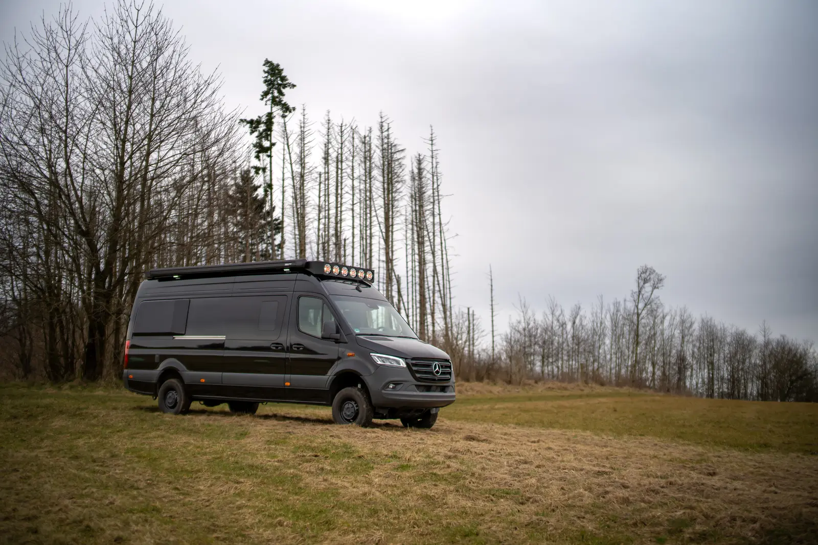 Schwarzer Allrad-Sprinter Emil mit Dachträger als autarker Camper-Ausbau