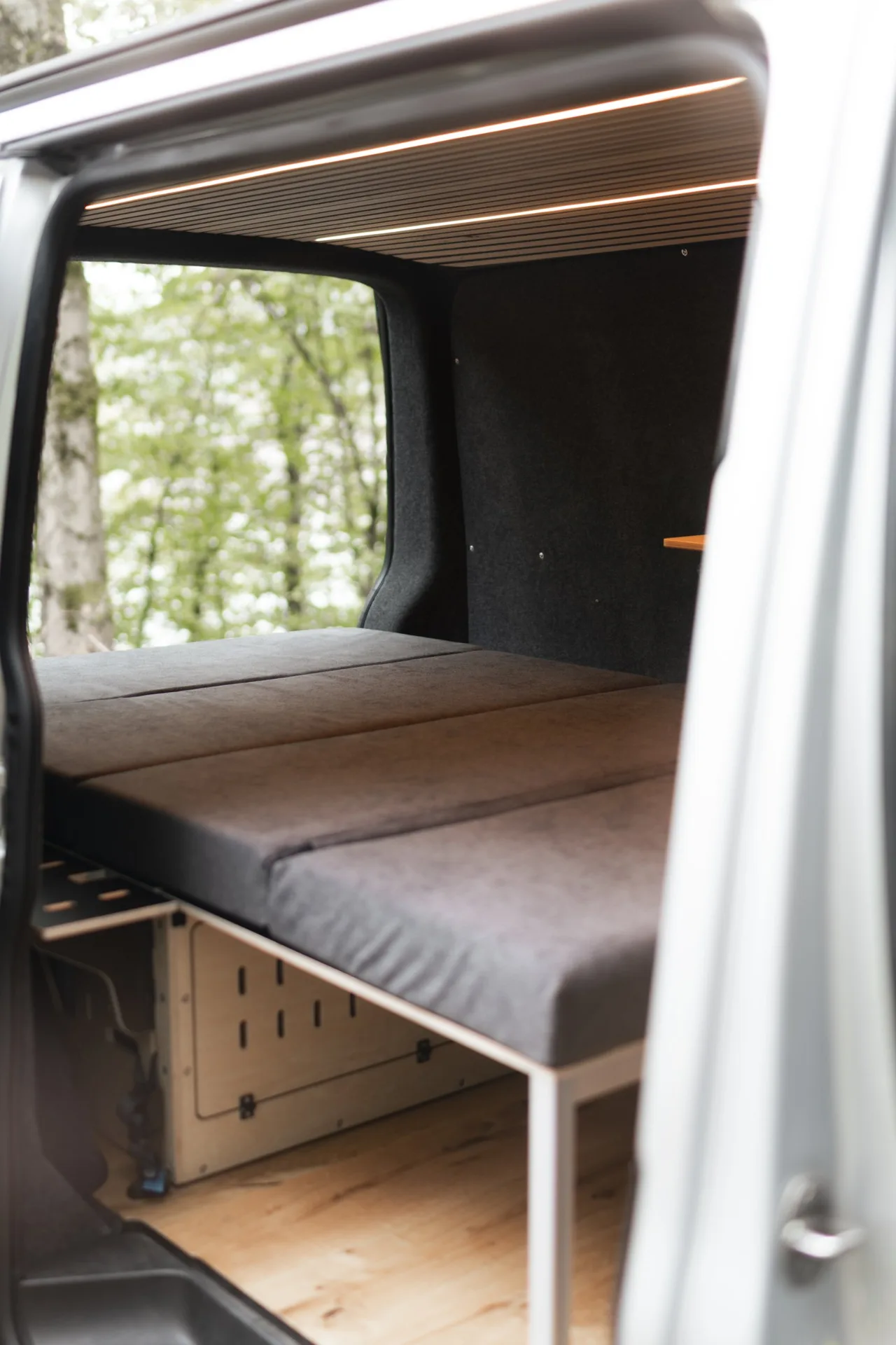 Blick durch die Schiebetür auf das Bett über der CampBoks